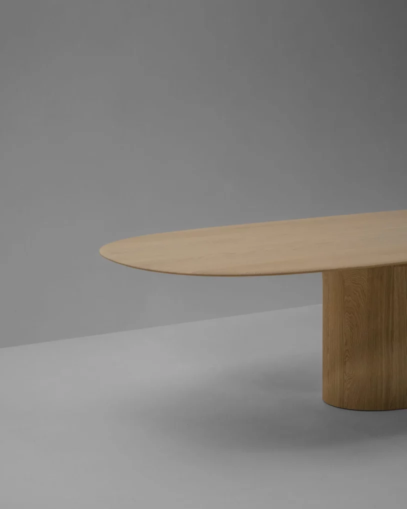 Anvil Dining Table Semi-Oval Van Rossum, ontwerp Pieter Maes, massief houten eettafel in eiken of walnoot met half-ovaal blad en sculpturale basis, verkrijgbaar bij Nuances Leuven