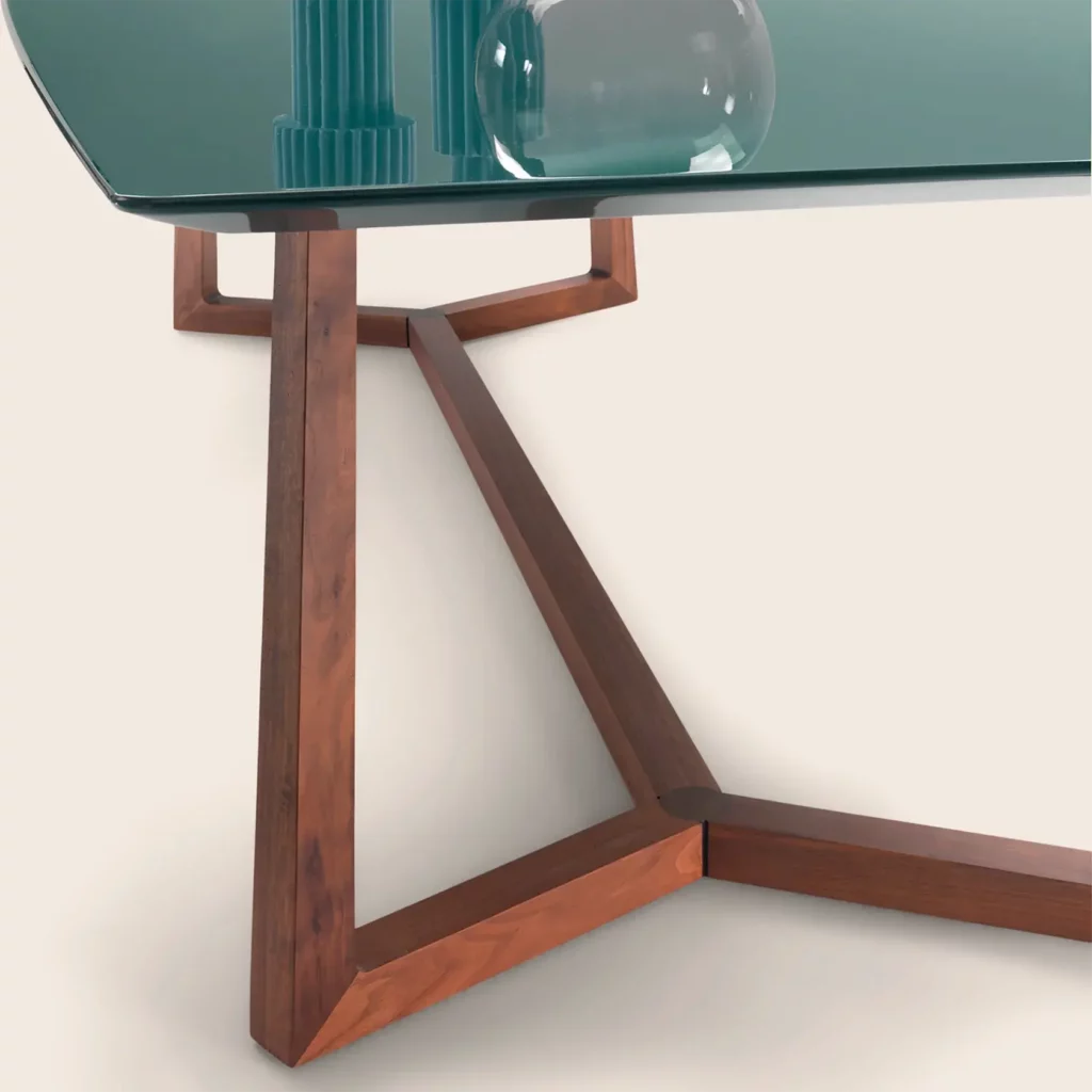 De Flexform Gipsy tafel maakt deel uit van een collectie tafels, salontafels en consoles die bekendstaat om hun strakke, tijdloze lijnen en subtiele, ambachtelijke details. Het onderstel is vervaardigd uit massief hout, verkrijgbaar in verschillende verfijnde tinten, en toont een uitzonderlijk niveau van houtbewerking. De vierkante poten, die op elegante wijze samenkomen op de drager, creëren een speels geometrisch effect dat de natuurlijke textuur van het hout extra in de verf zet. Het tafelblad vormt een mooi contrast met de warme houtstructuur en is beschikbaar in hoogglanslak of achtergelakt glas, telkens in een palet van verfijnde, diepe kleuren. De rechthoekige vorm van het blad krijgt extra karakter door de verfijnde contouren: slanker aan kop- en voeteneind, met licht gebogen lange zijden voor een subtiel dynamische uitstraling. Verkrijgbaar bij Nuances in Leuven, specialist in Italiaans high-end interieurdesign, is de Flexform Gipsy tafel een perfecte keuze voor wie op zoek is naar een stuk dat poëtische ambacht, grafische zuiverheid en moderne elegantie combineert in één harmonieus ontwerp.